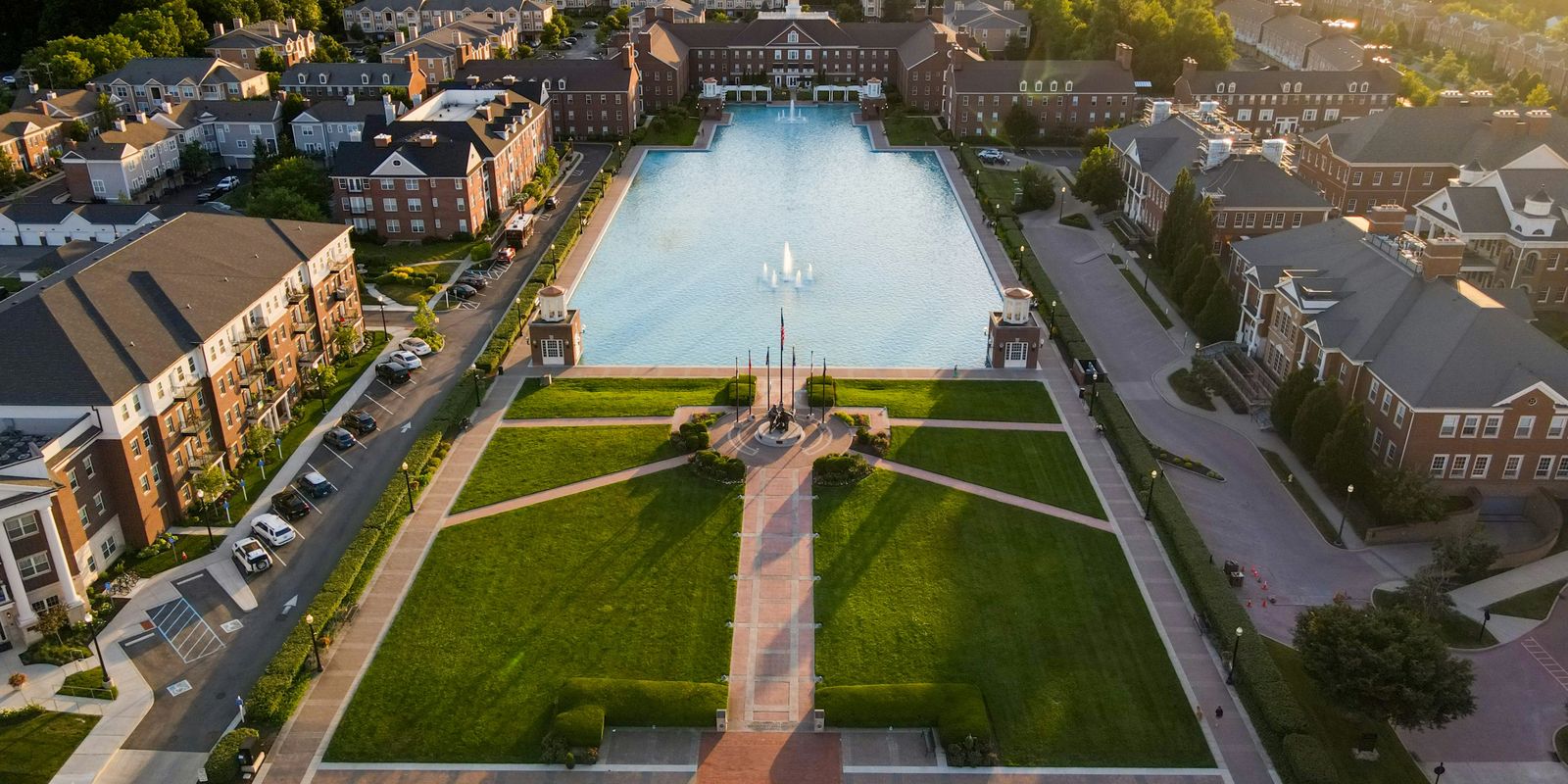 Aerial view of a reflecting pool, fountain and brick buildings in Carmel, Indiana, at sunset